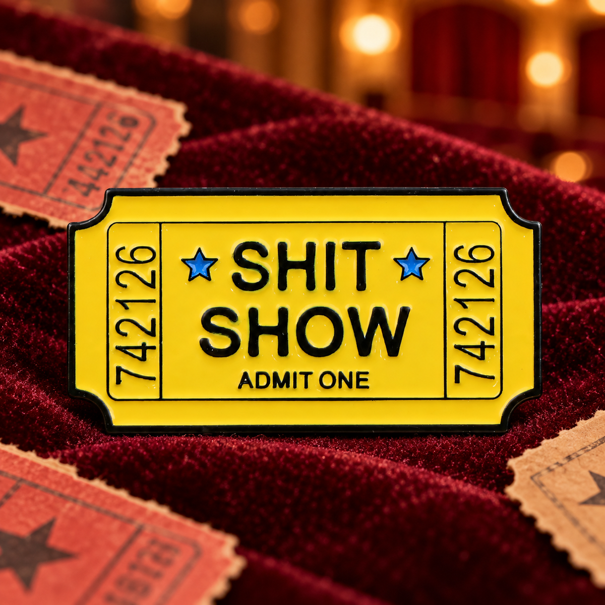 Shit Show Ticket Pin enamel pin in a styled lifestyle setting