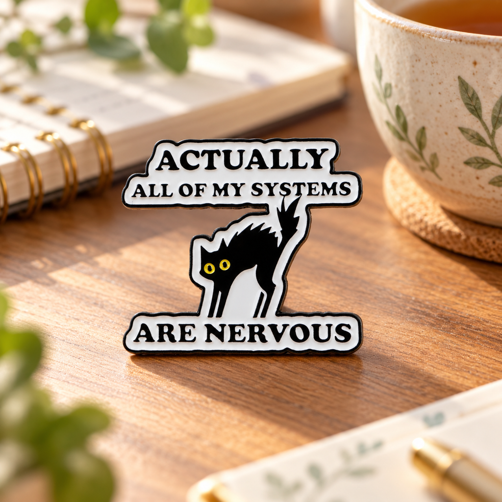 Actually All Of My Systems Are Nervous enamel pin on a cozy desk