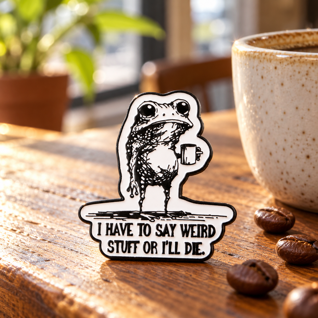 I Have to Say Weird Stuff or I Will Die Frog Drinking Coffee Pin displayed in a styled lifestyle setting