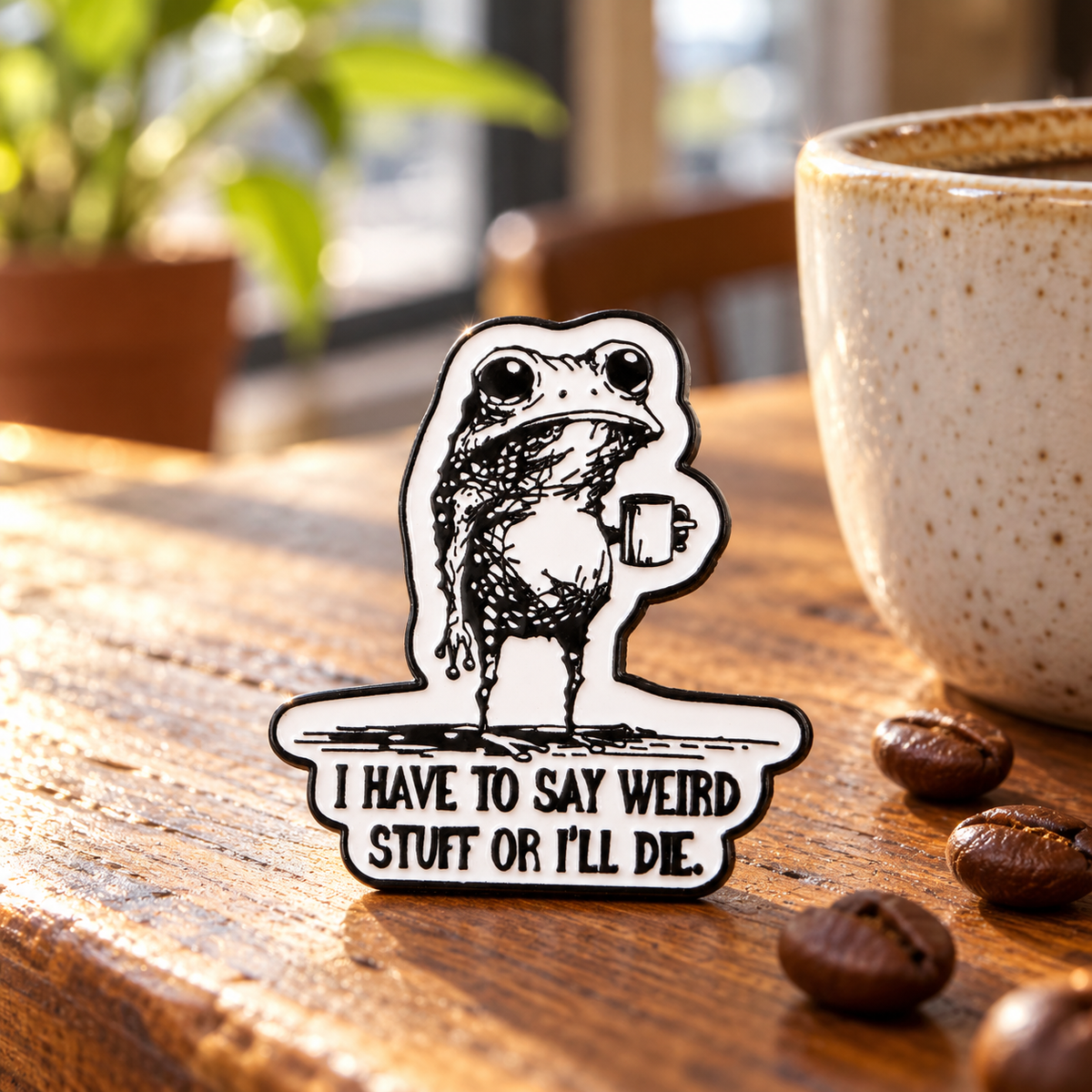 I Have to Say Weird Stuff or I Will Die Frog Drinking Coffee Pin displayed in a styled lifestyle setting