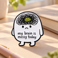 My Brain Is Messy Today enamel pin on a calm sunlit desk