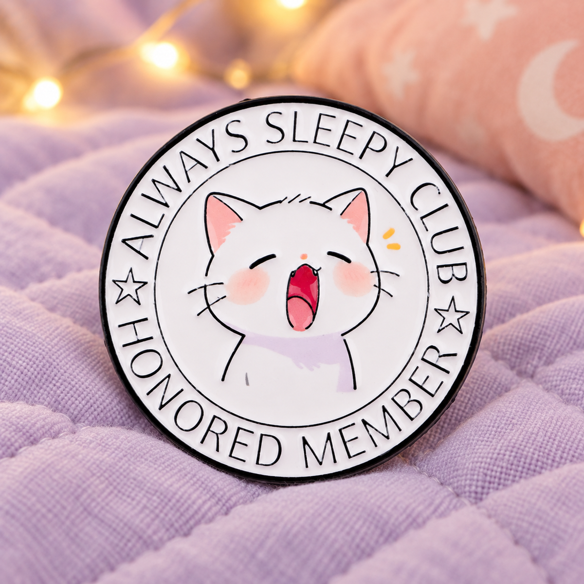 Always Sleepy Club Cat Pin on a soft lavender quilt