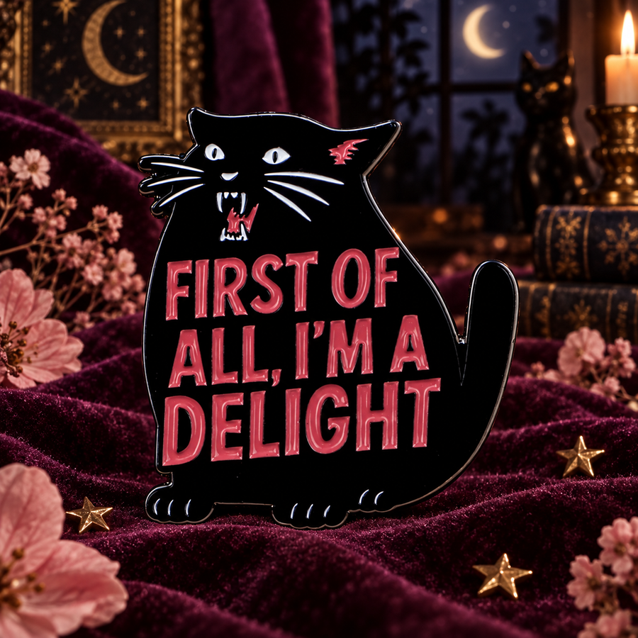 Black cat enamel pin on plum velvet at night
