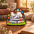 Calico Cat Sleeping on Books enamel pin in a cozy reading nook