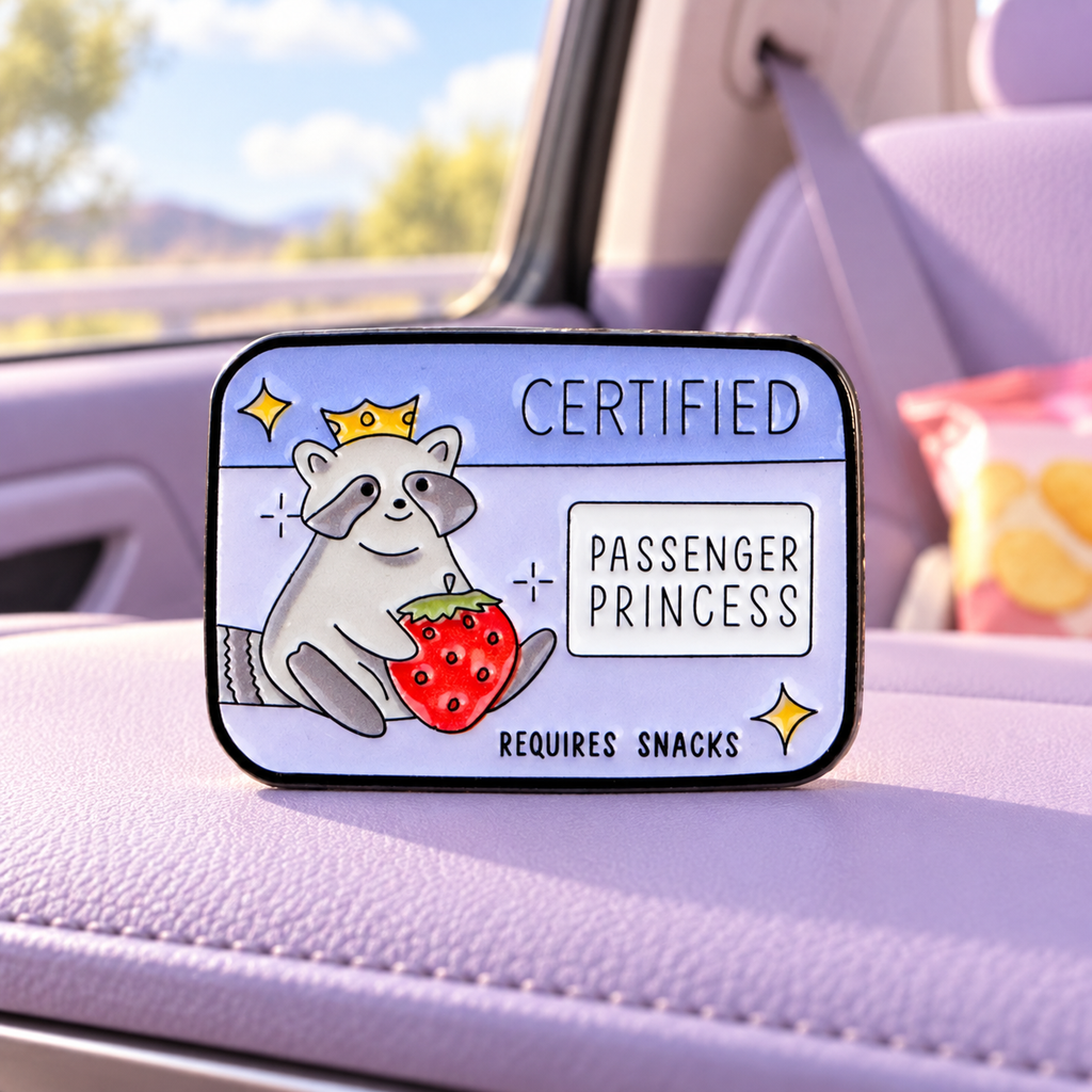 Certified Passenger Princess Raccoon Pin on a lavender road trip seat