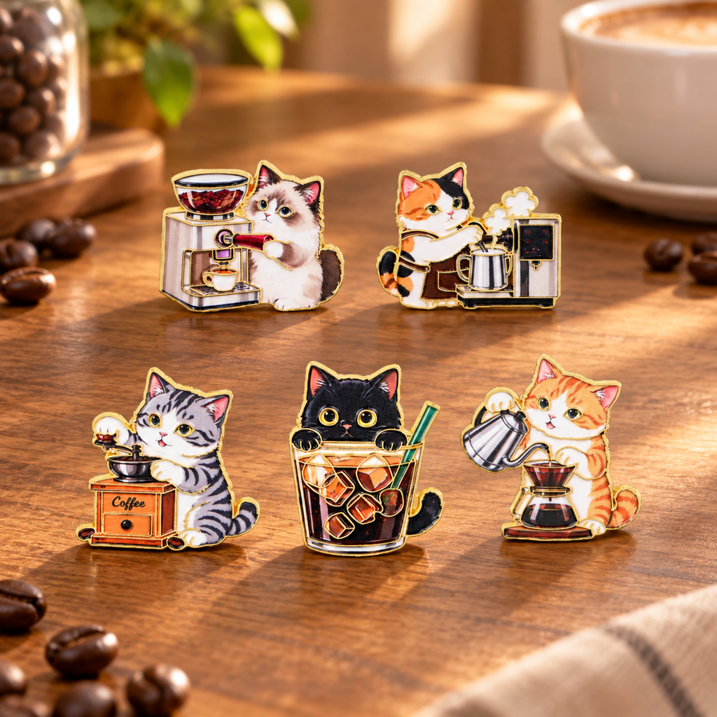 Five coffee cat enamel pins on a sunny cafe table