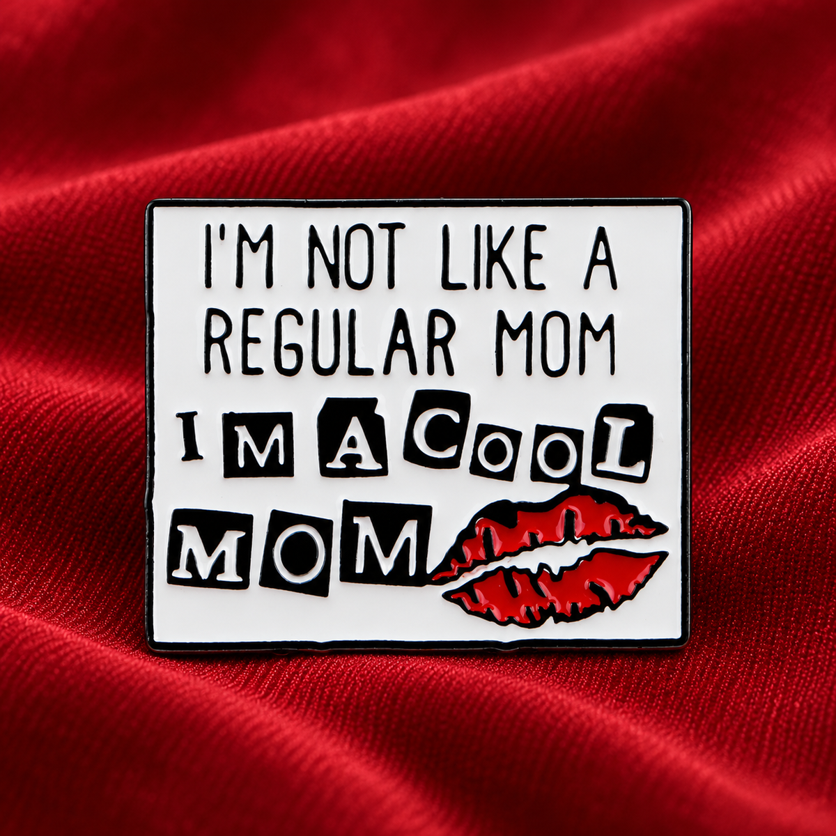 I'm Not Like a Regular Mom I'm a Cool Mom enamel pin on red fabric