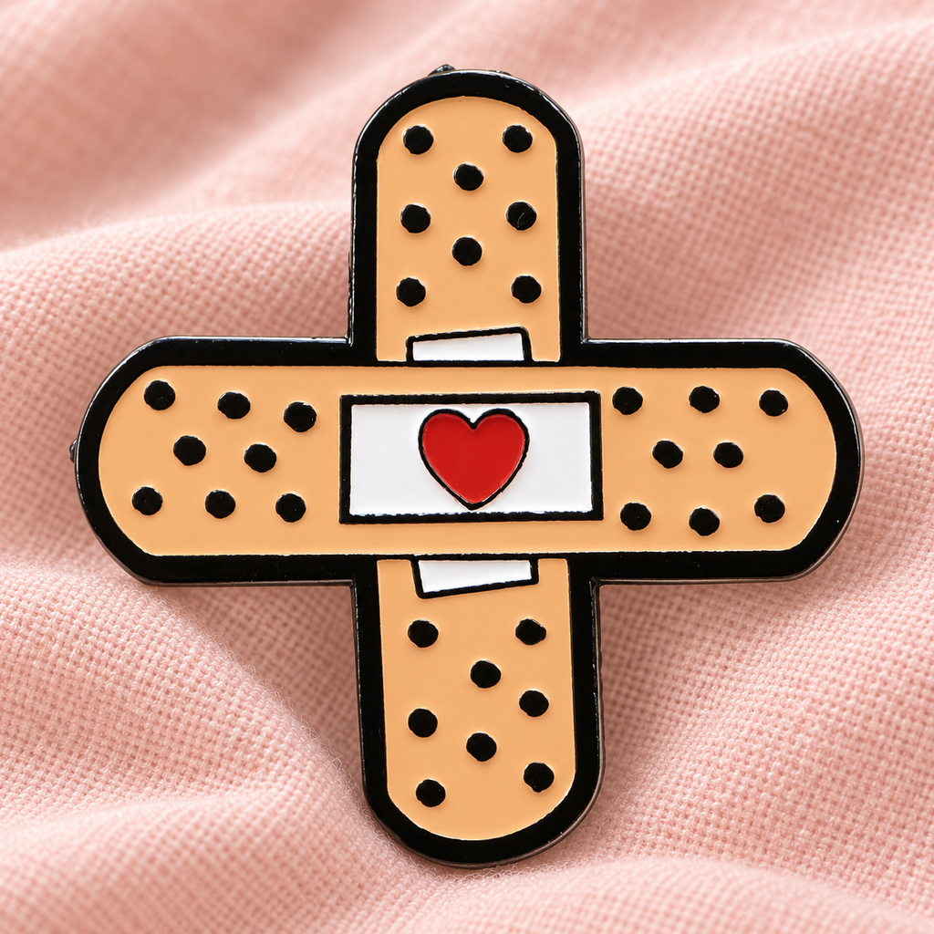 Cross Band-Aid enamel pin on blush fabric