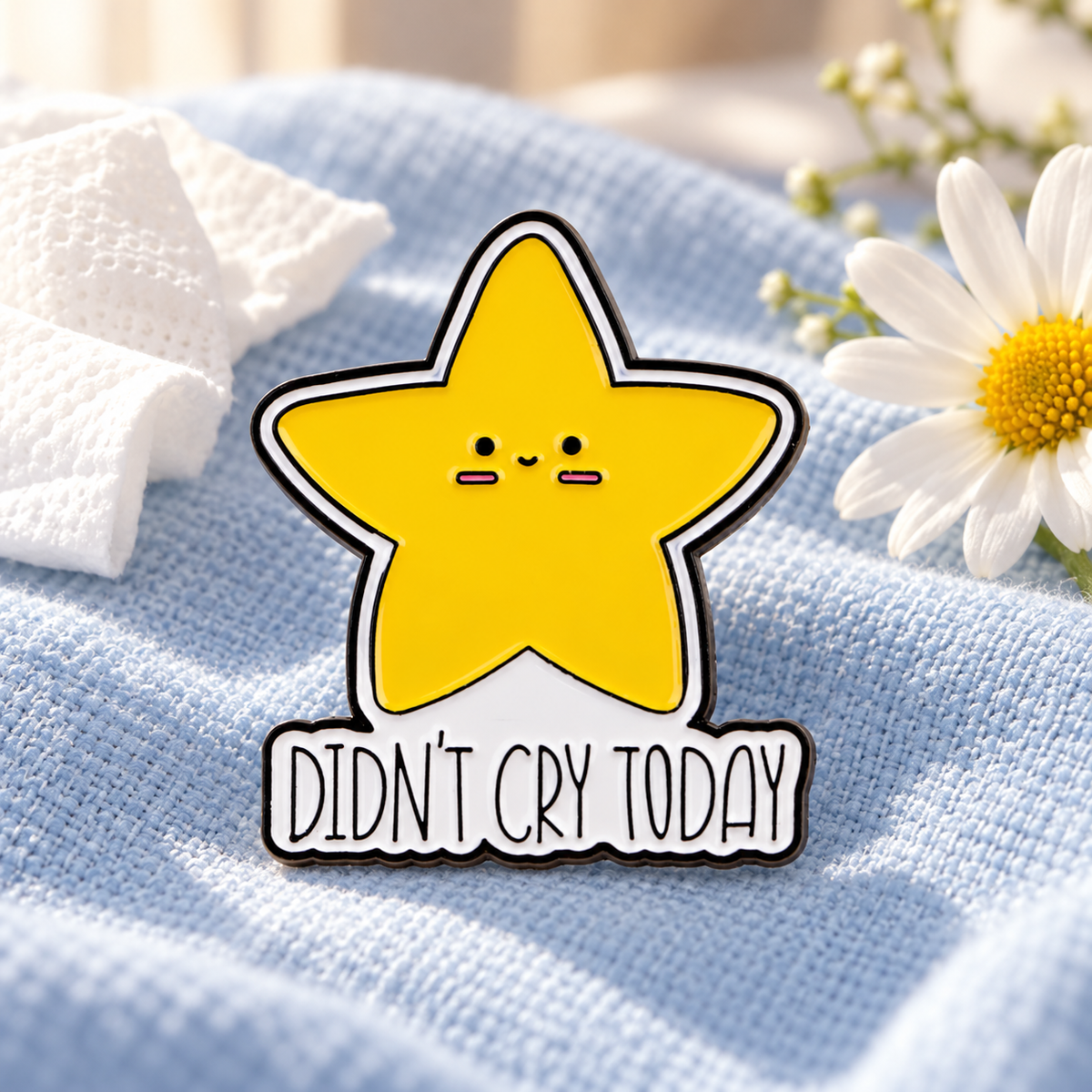 DIDN'T CRY TODAY star enamel pin displayed on soft blue fabric with a daisy