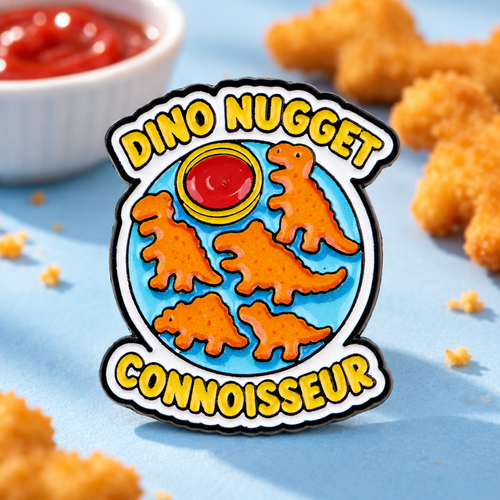 Dino Nugget Connoisseur pin on a blue tabletop with dinosaur nuggets and dipping sauce