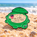 Do It for Little You Turtle enamel pin on a sunlit beach background