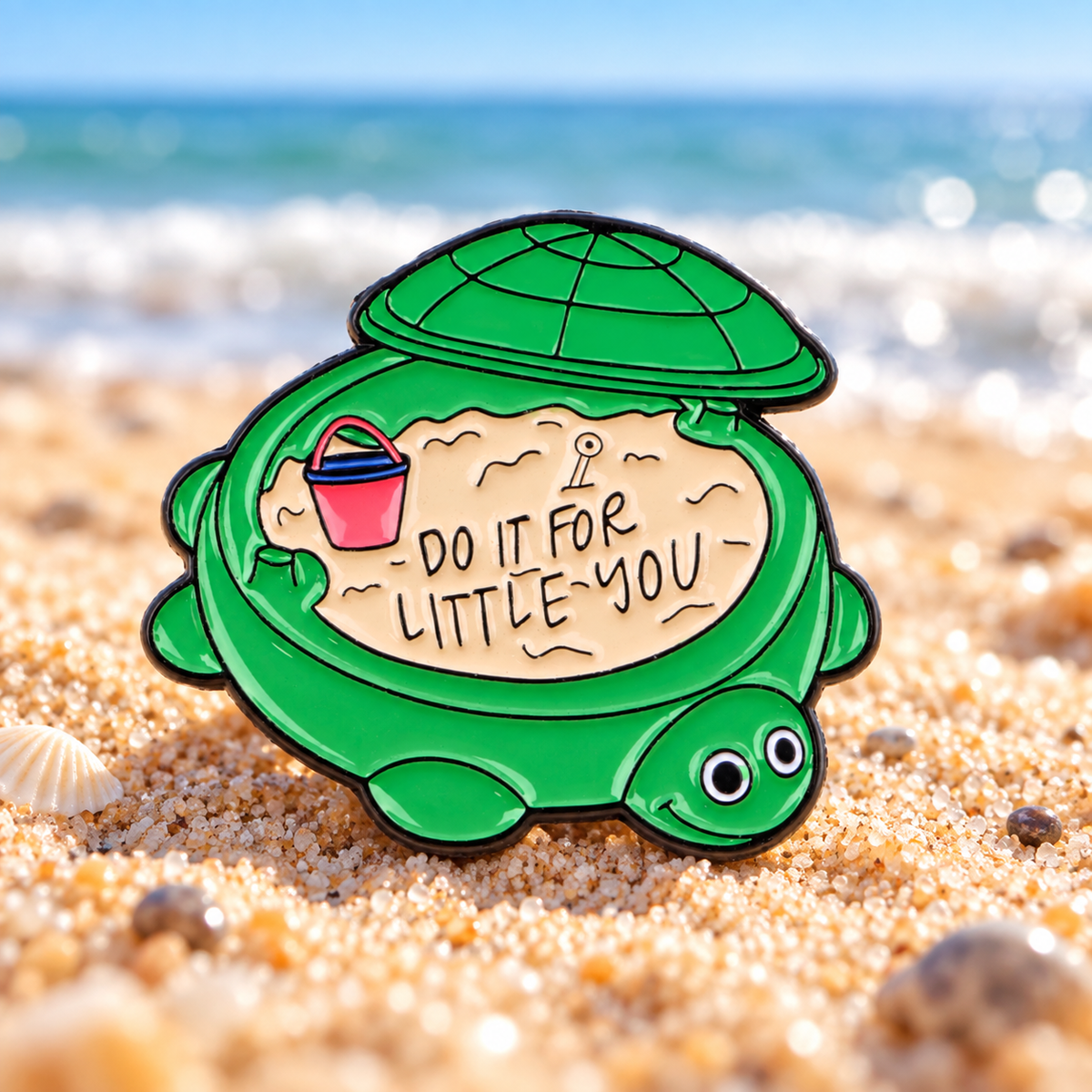 Do It for Little You Turtle enamel pin on a sunlit beach background