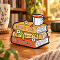 Drink Tea and Read Books enamel pin in a cozy reading nook