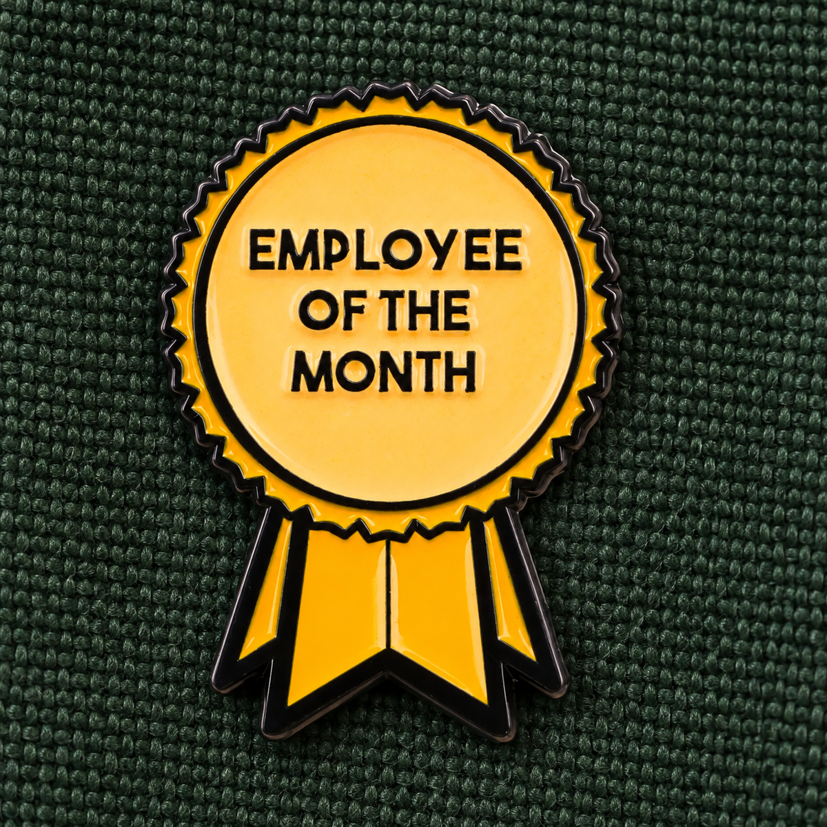 Employee of the Month enamel pin on forest green canvas