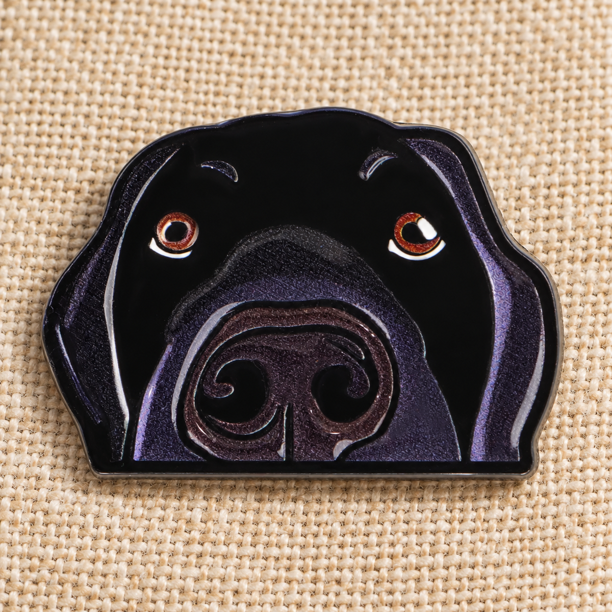 Black Labrador enamel pin on beige linen