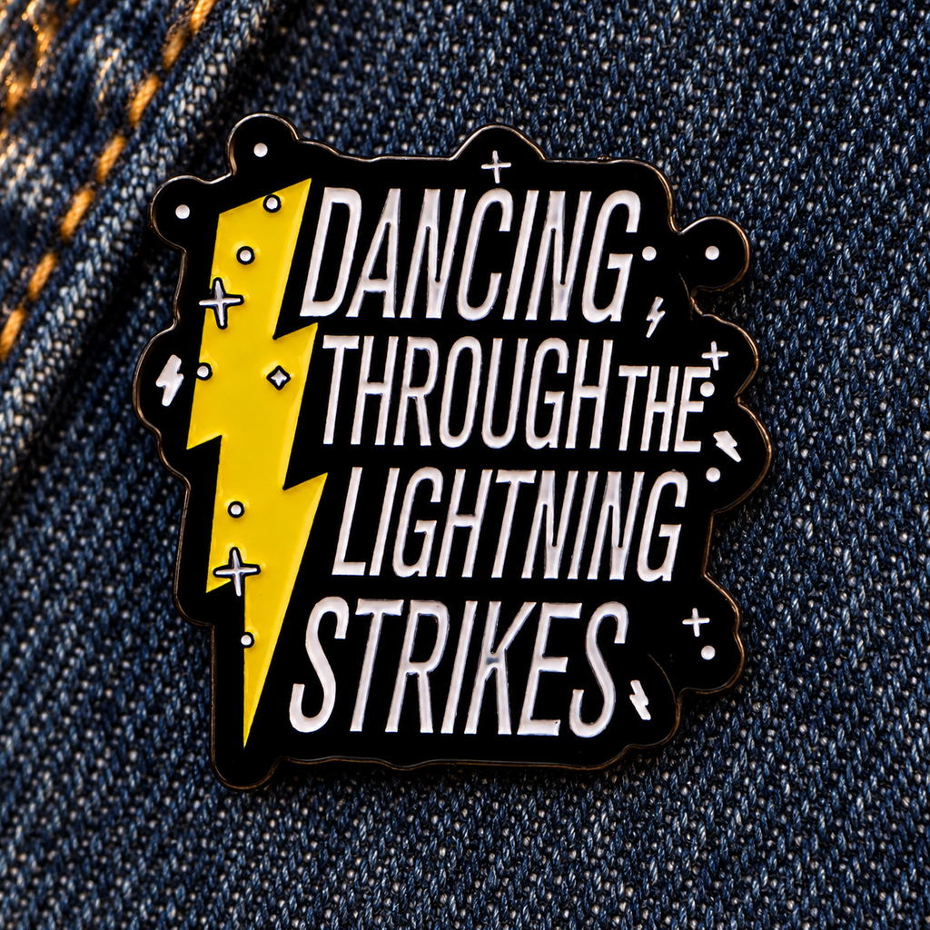 Dancing Through The Lightning Strikes enamel pin on indigo denim