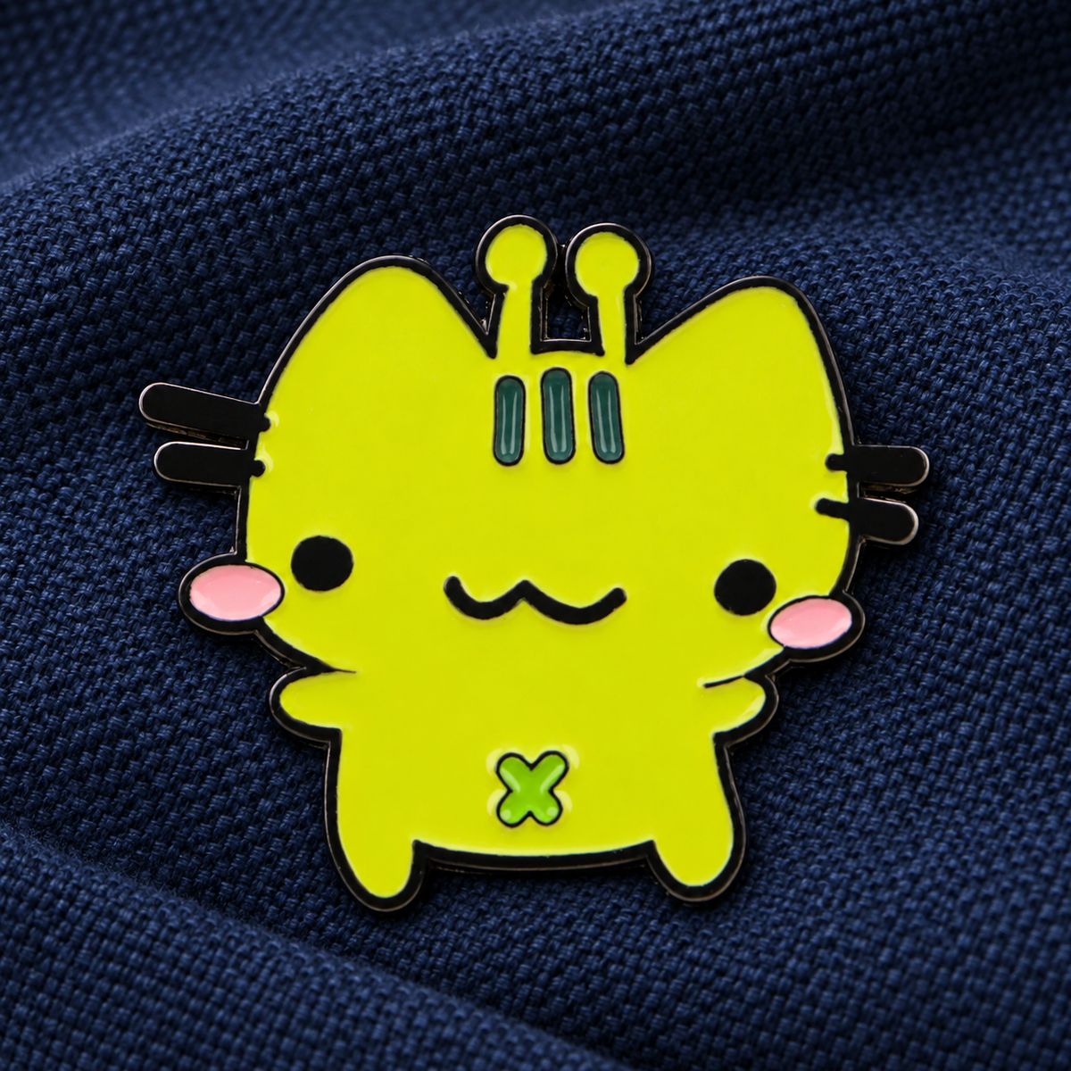 Silly Alien Cat enamel pin on dark navy fabric