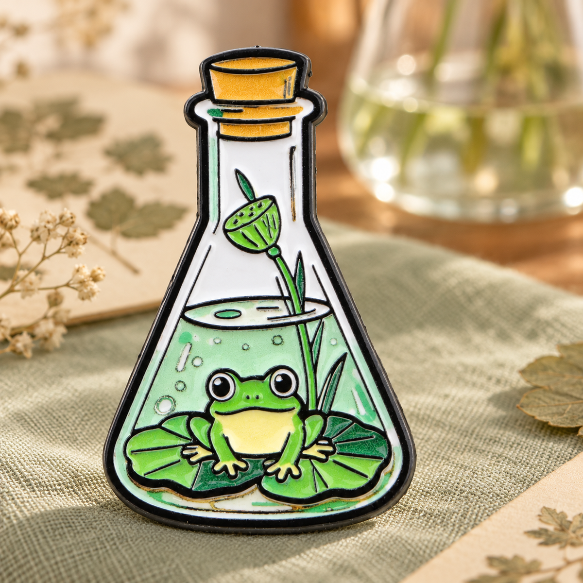 Erlenmeyer Green Frog enamel pin on a botanical science desk
