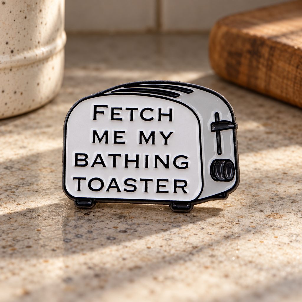 Fetch Me My Bathing Toaster enamel pin on a retro kitchen counter
