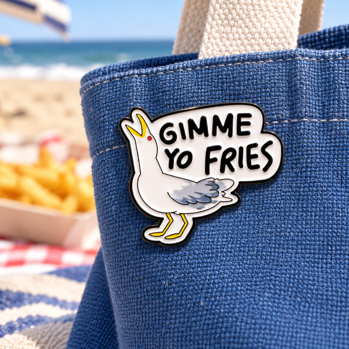 Pin mouette GIMME YO FRIES sur sac bleu à la plage