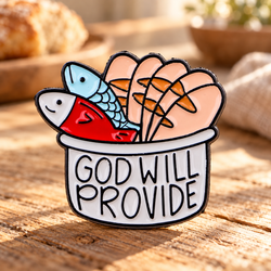 God Will Provide Bread and Fish Pin on sunlit rustic table