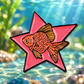 Goldfish on a Pink Star enamel pin with a softly lit aquarium backdrop