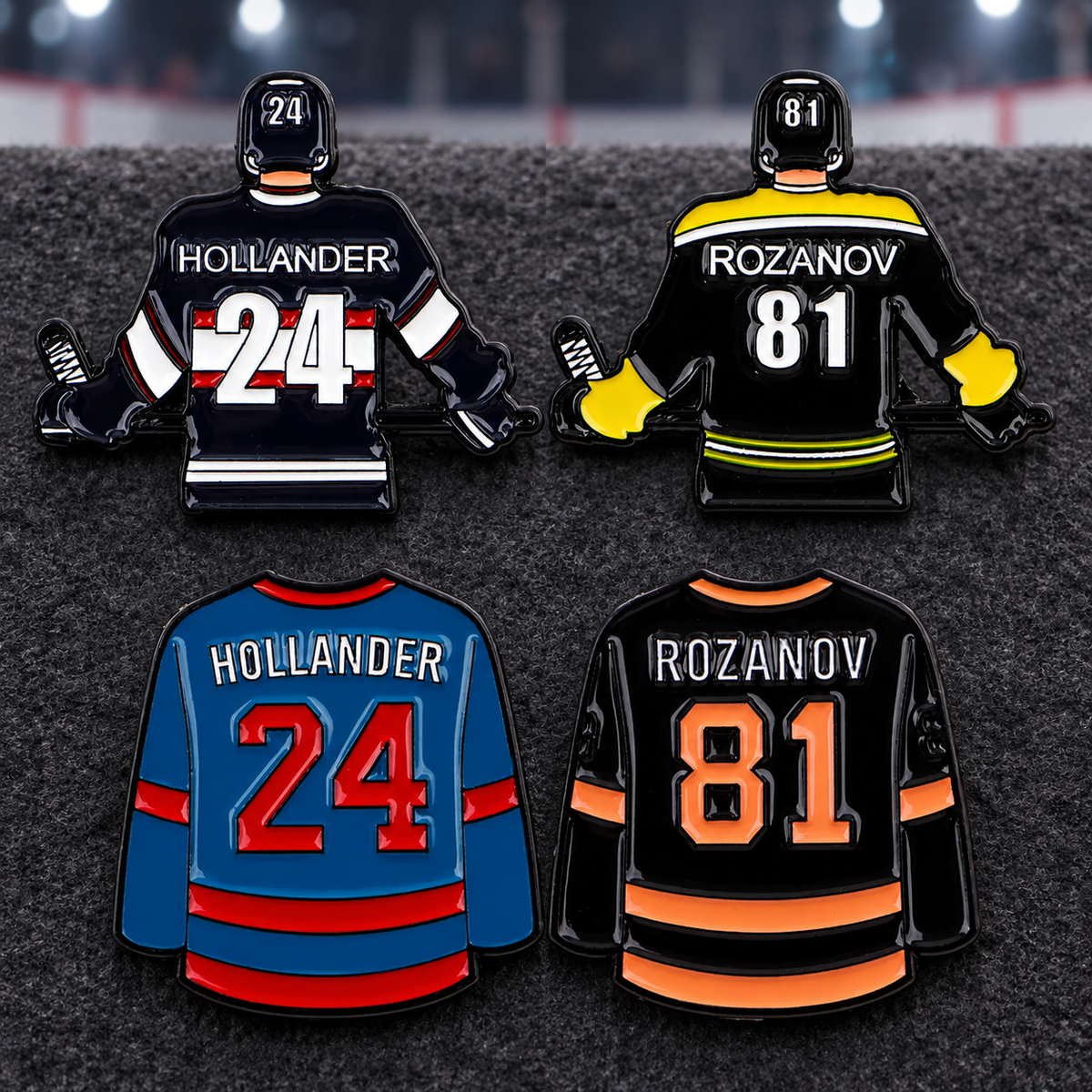 Four hockey jersey enamel pins displayed on charcoal felt