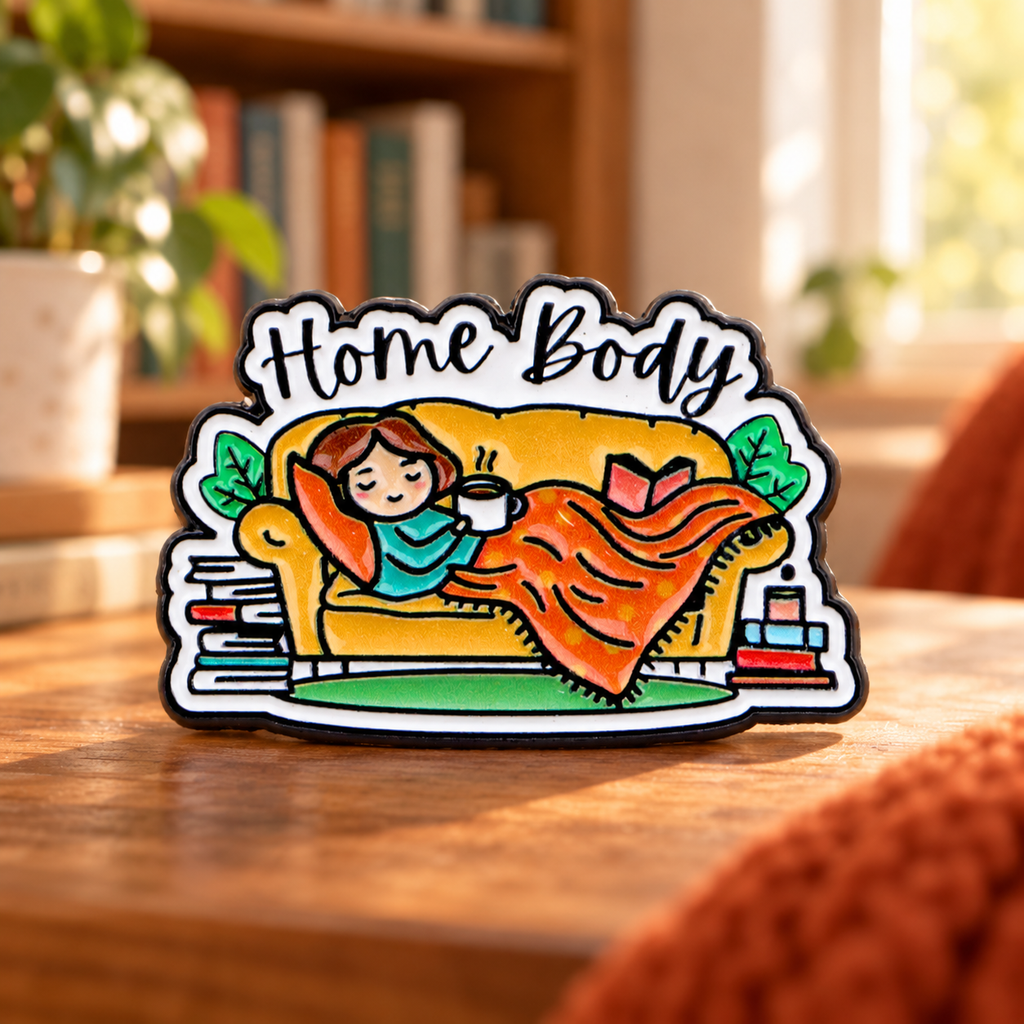 Home Body Books and Blanket enamel pin in a cozy reading nook