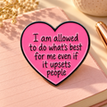 Pink heart enamel pin on a sunlit blush journal