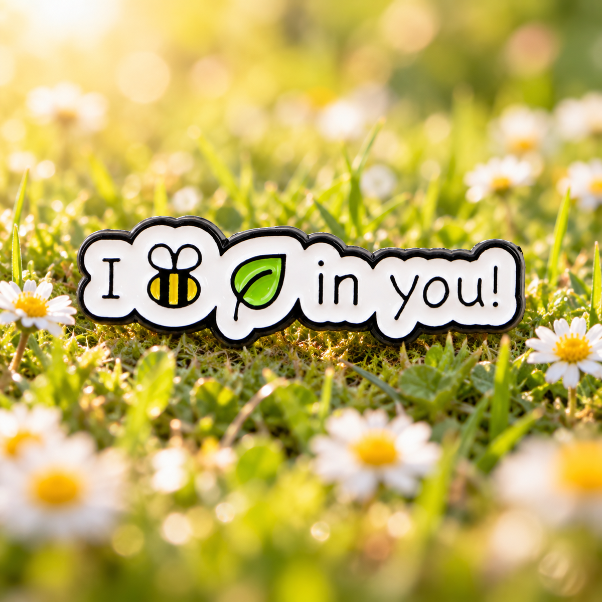 I Bee-Leaf in You enamel pin in a spring meadow