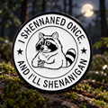 I Shenaned Once Raccoon enamel pin in a moonlit forest