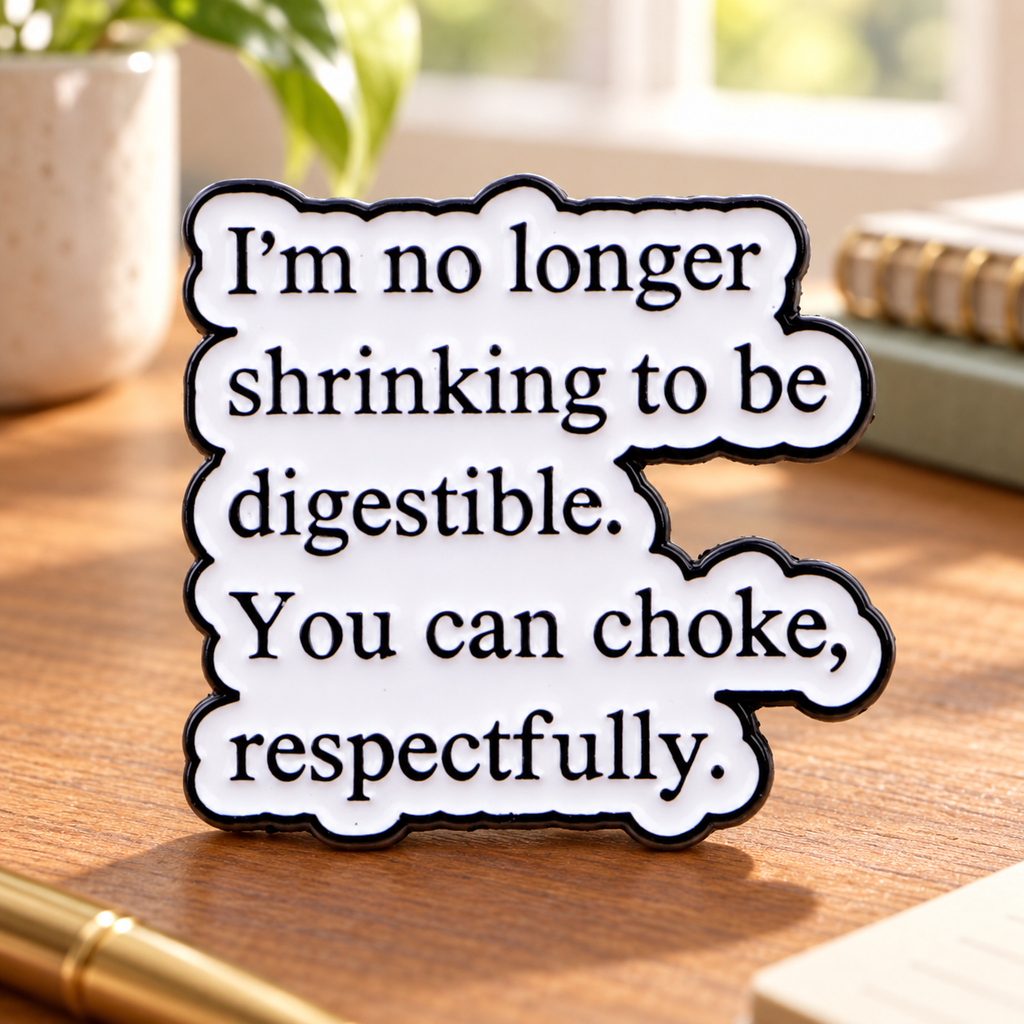 I'm No Longer Shrinking enamel quote pin on a sunlit writing desk