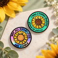 Two sunflower invisible disability enamel pins on a calm botanical background
