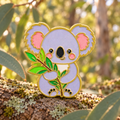 Koala Holding Eucalyptus Pin in a sunlit woodland