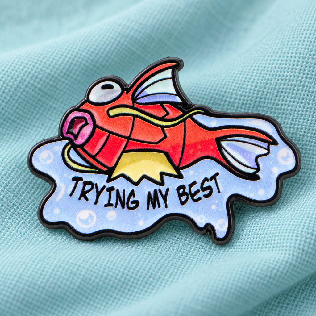 Trying My Best fish enamel pin on aqua fabric