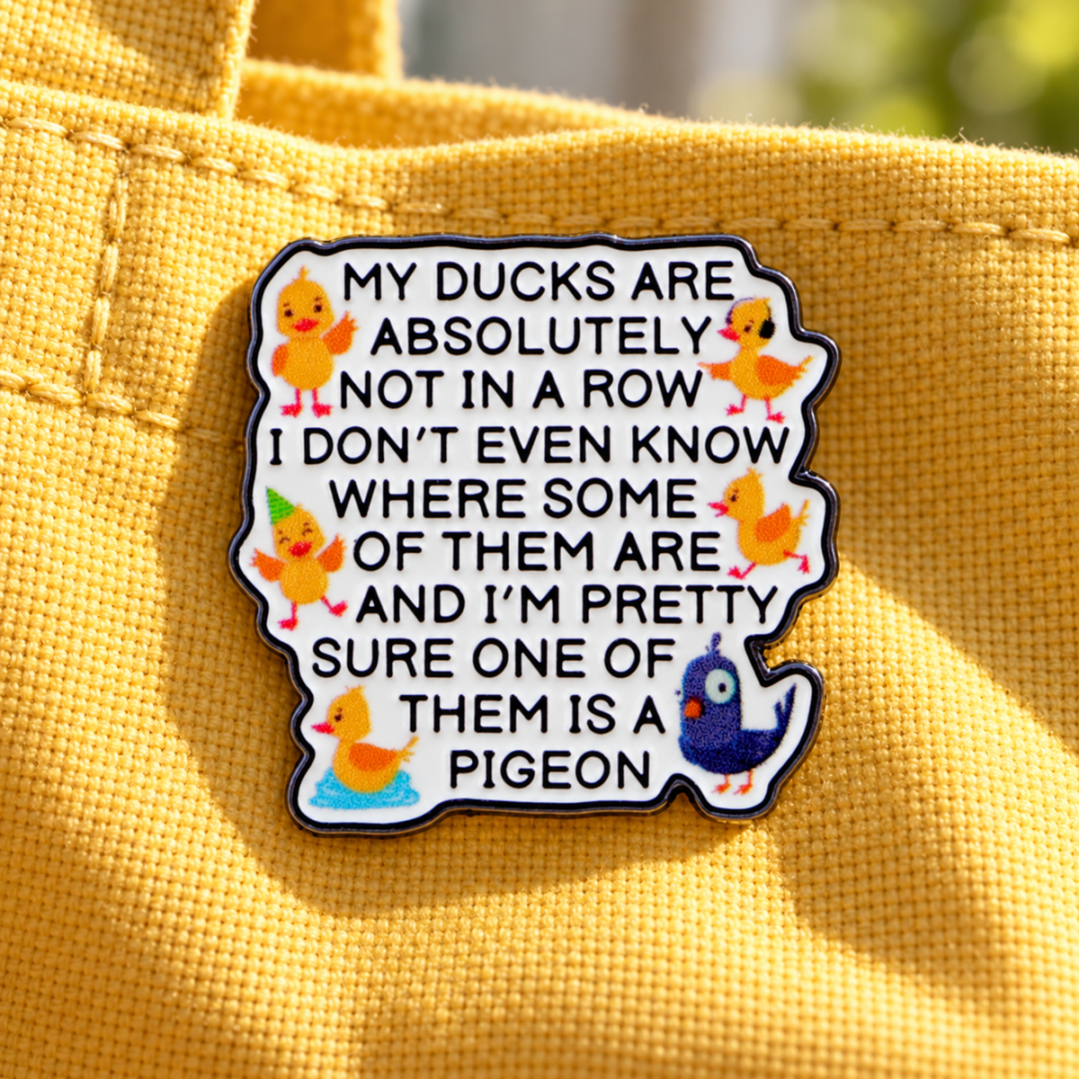 My Ducks Are Absolutely Not in a Row enamel pin on yellow canvas