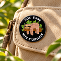 Not Fast Not Furious Sloth enamel pin on a beige canvas backpack