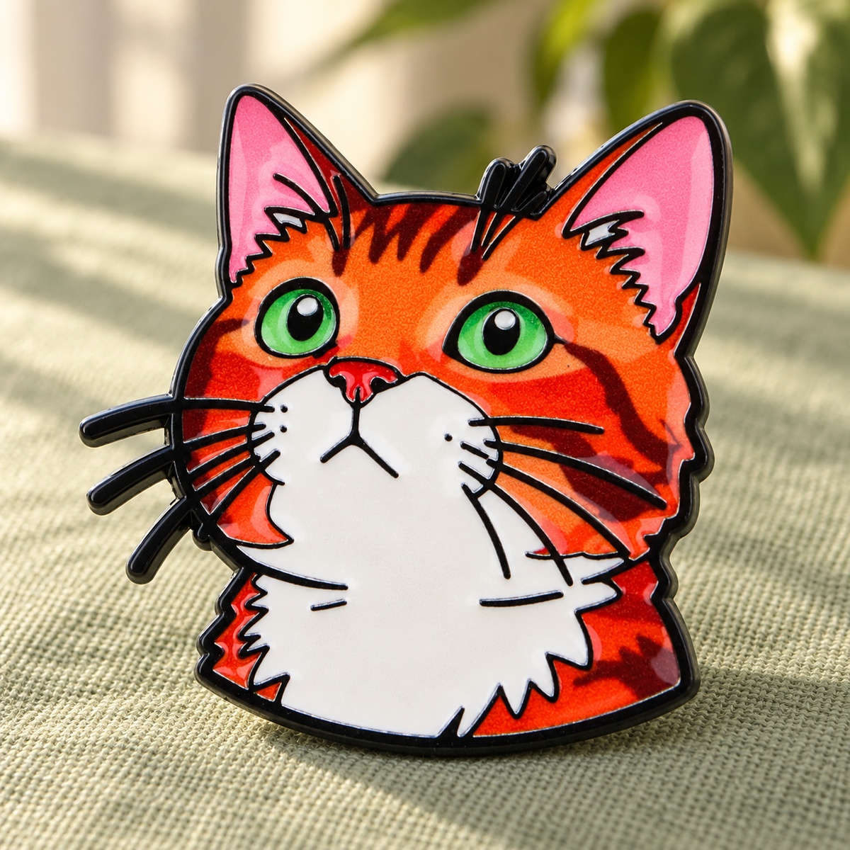 Orange cat with green eyes enamel pin on sage linen