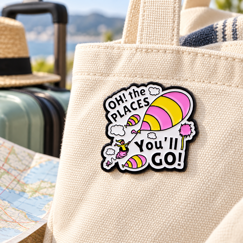 Oh the Places You'll Go enamel pin on a travel tote