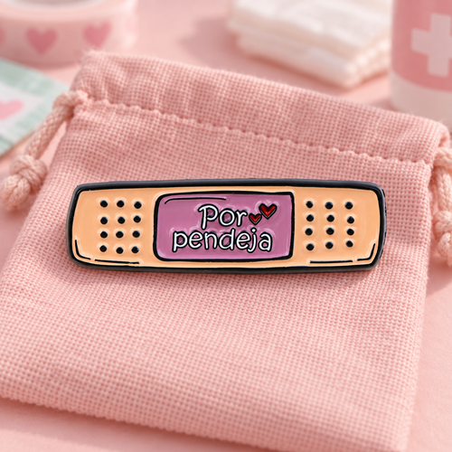 Por Pendeja bandage enamel pin on a blush-pink pouch