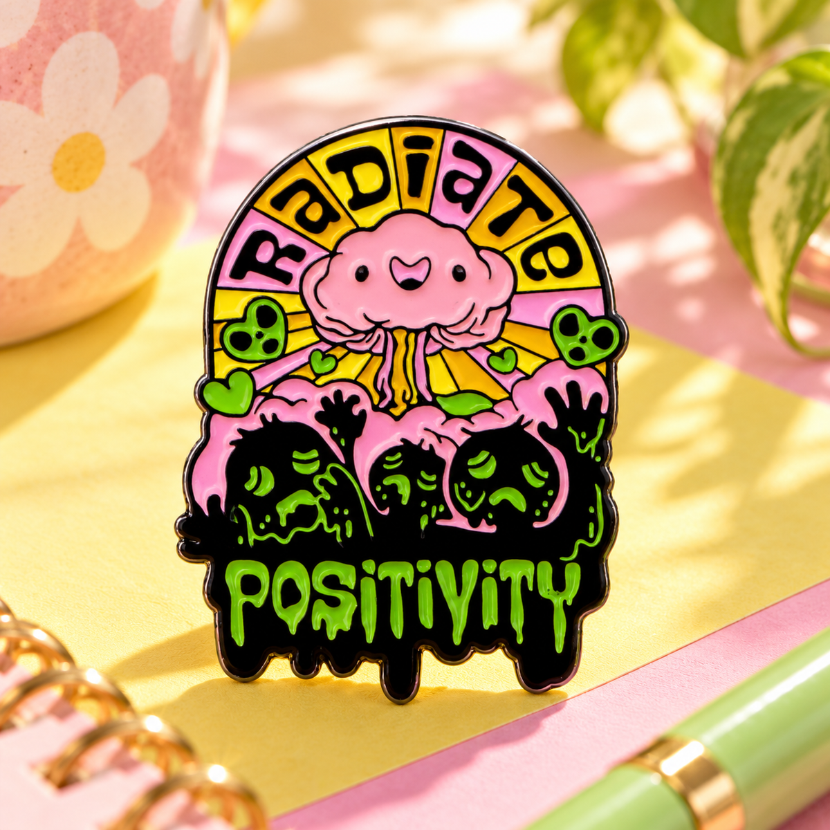 Radiate Positivity enamel pin displayed in a cheerful retro pastel desk setting