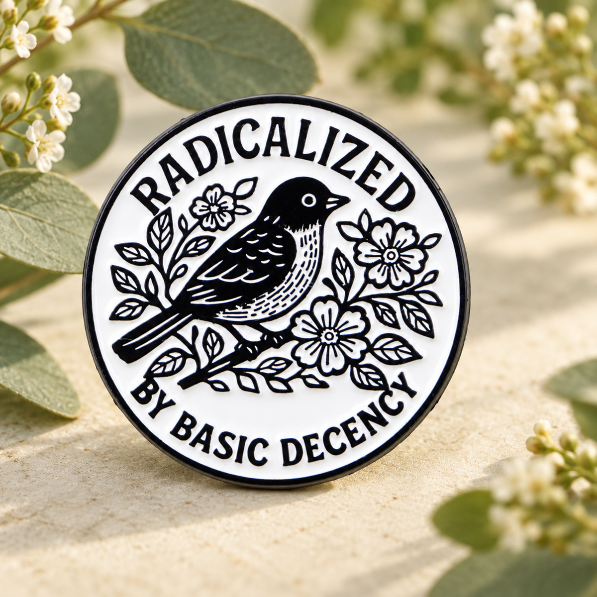 Radicalized by Basic Decency bird enamel pin in a sage botanical scene
