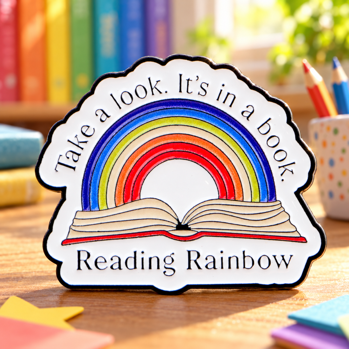 Reading Rainbow enamel pin in a cheerful sunlit reading nook
