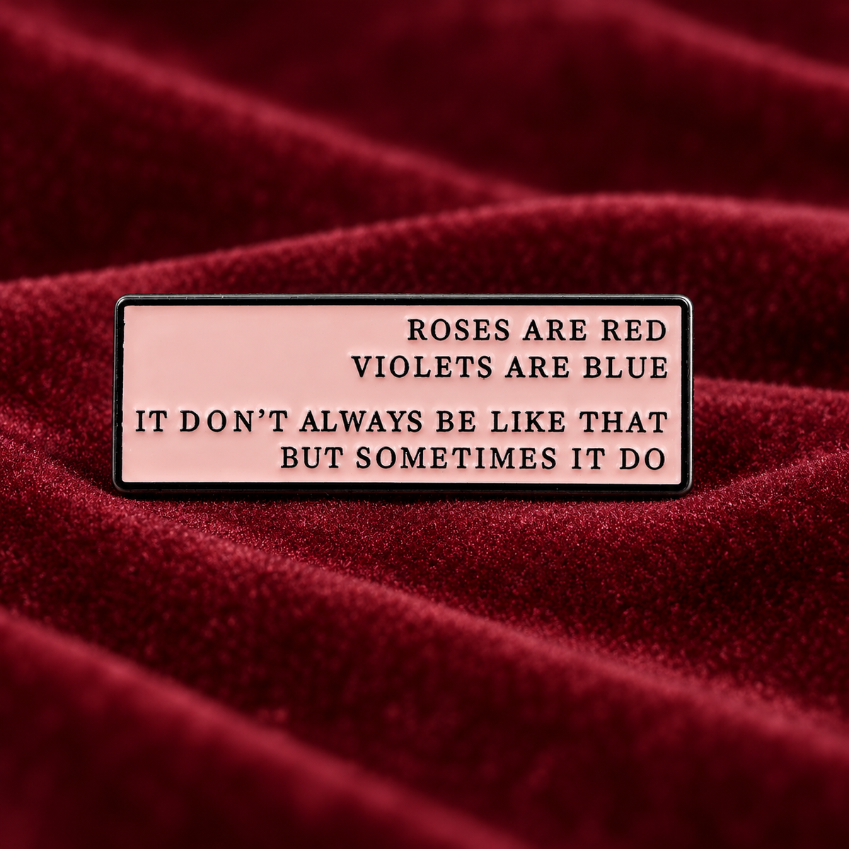 Roses Are Red Violets Are Blue enamel pin on burgundy velvet
