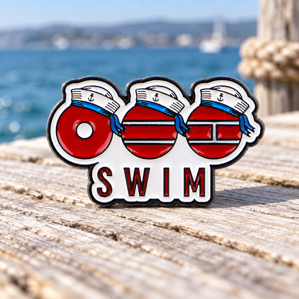 SWIM sailor enamel pin beside the sea